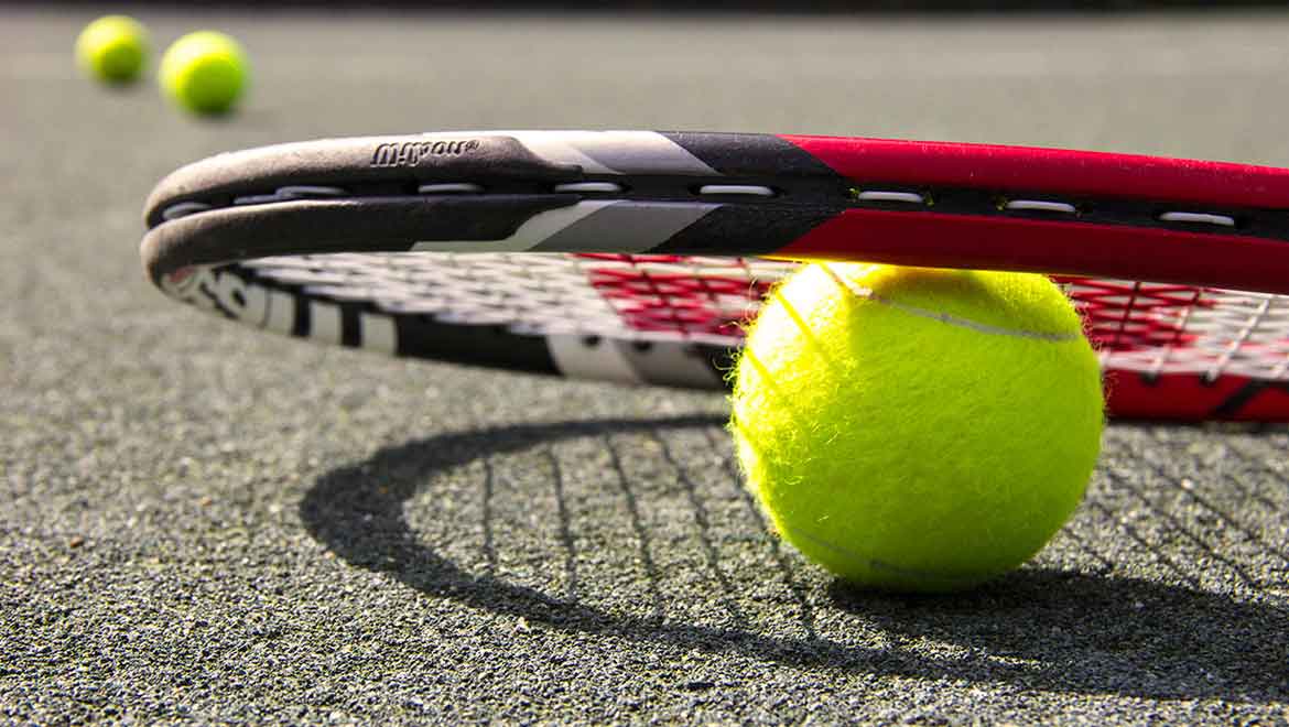 Racket on top of a tennis ball