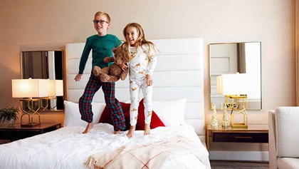 Two kids jumping on the bed