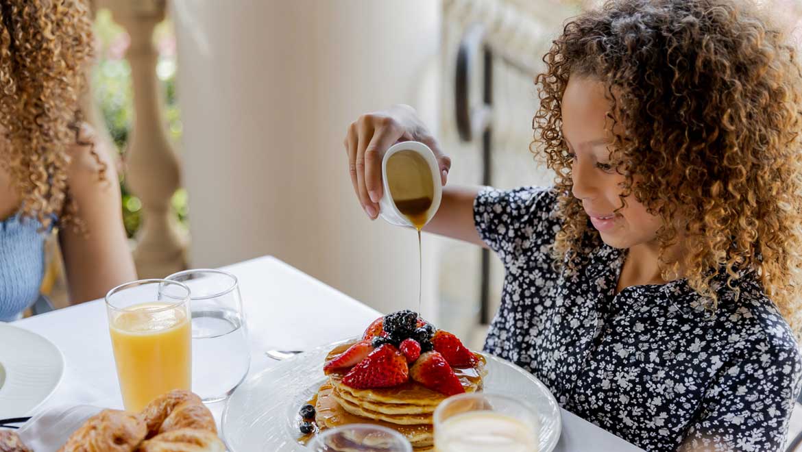 young girl eating breakfast