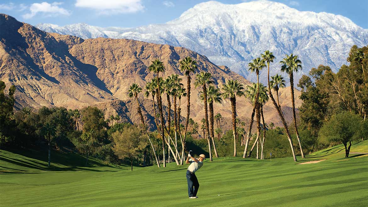 Man hitting a golf ball on the golf course.