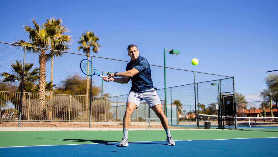 Man ready to strike a tennis ball.