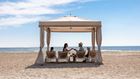 family relaxing in beach cabana