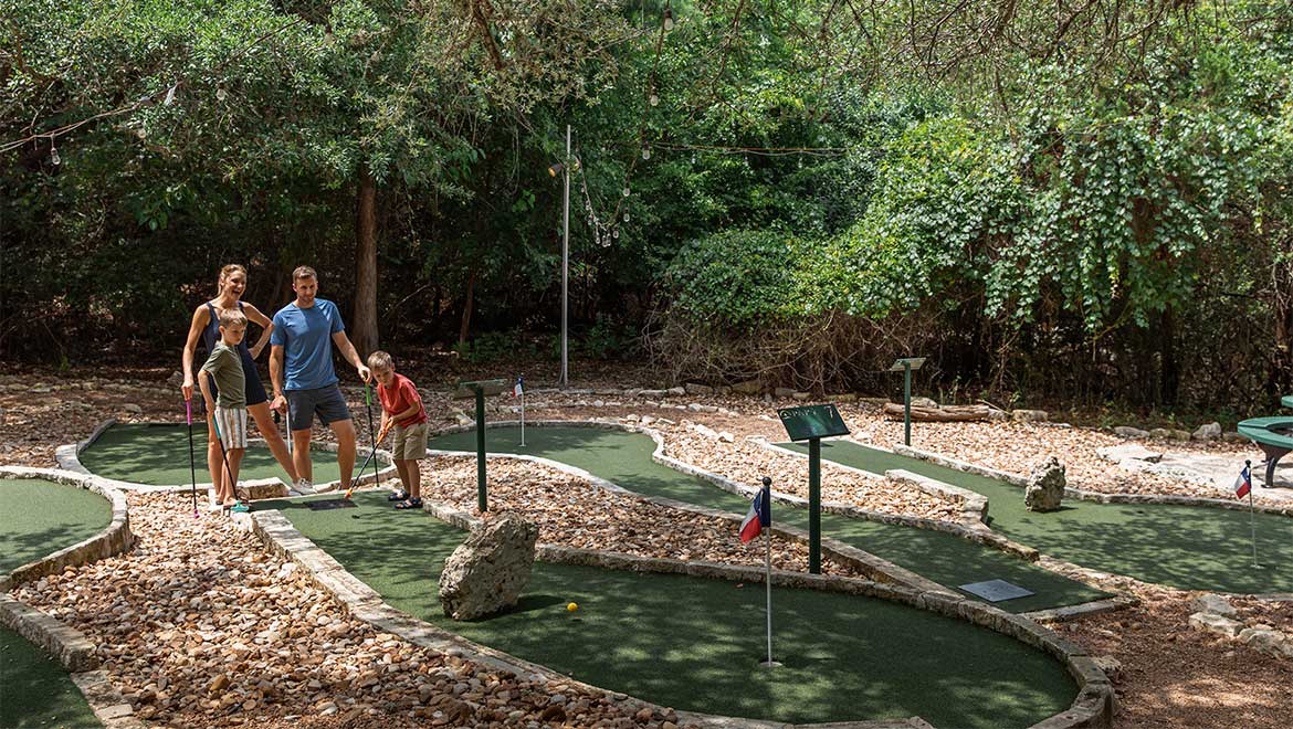 family playing mini golf