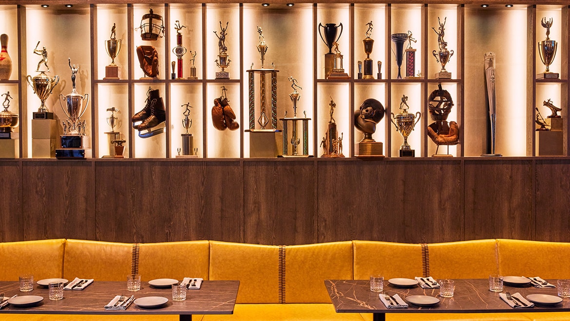  A large trophy installation anchors the Trophy Room inside The Sporting Club, highlighting the camaraderie, culture and excitement of sport - Omni Boston Hotel at the Seaport