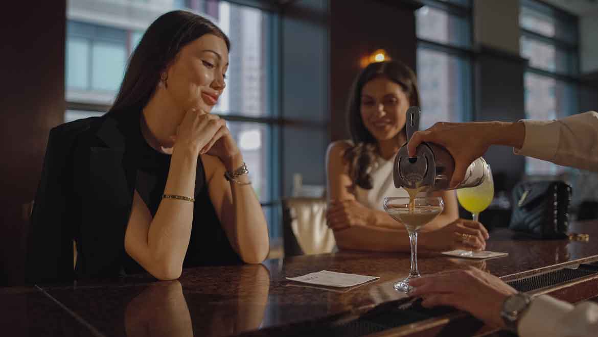 Bartender pouring woman a drink.
