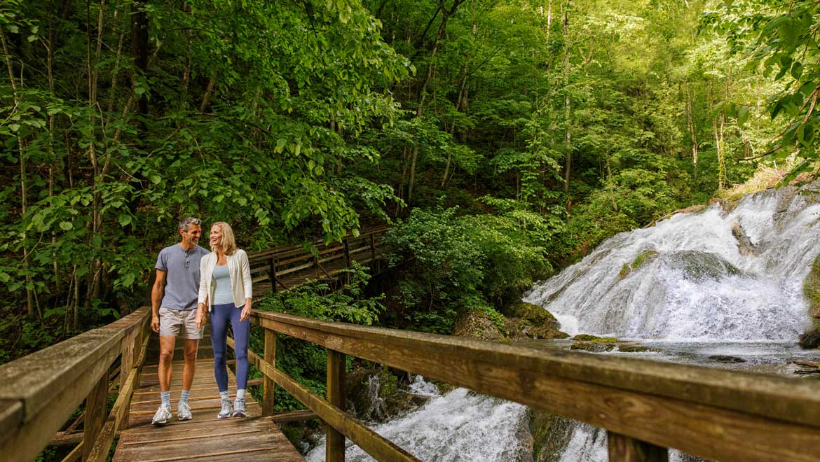 Couple hiking across bridge.