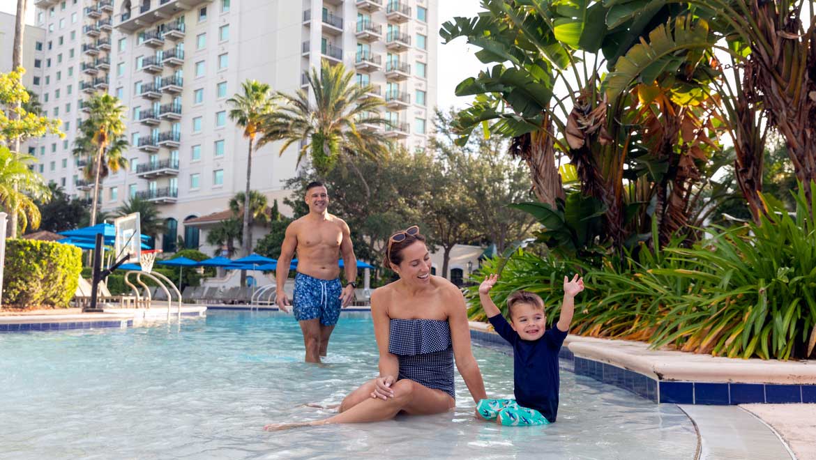 Family playing in resort pool