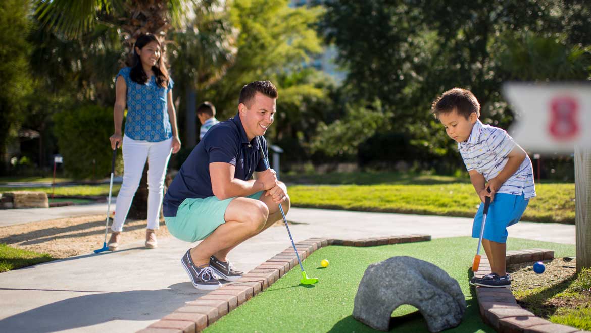 Family playing mini golf