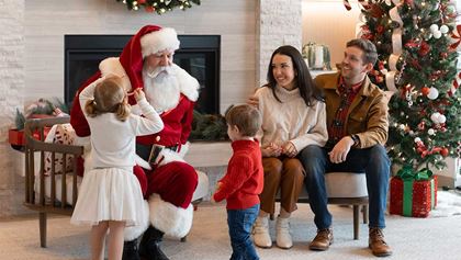 Family sitting with Santa by the fireplace