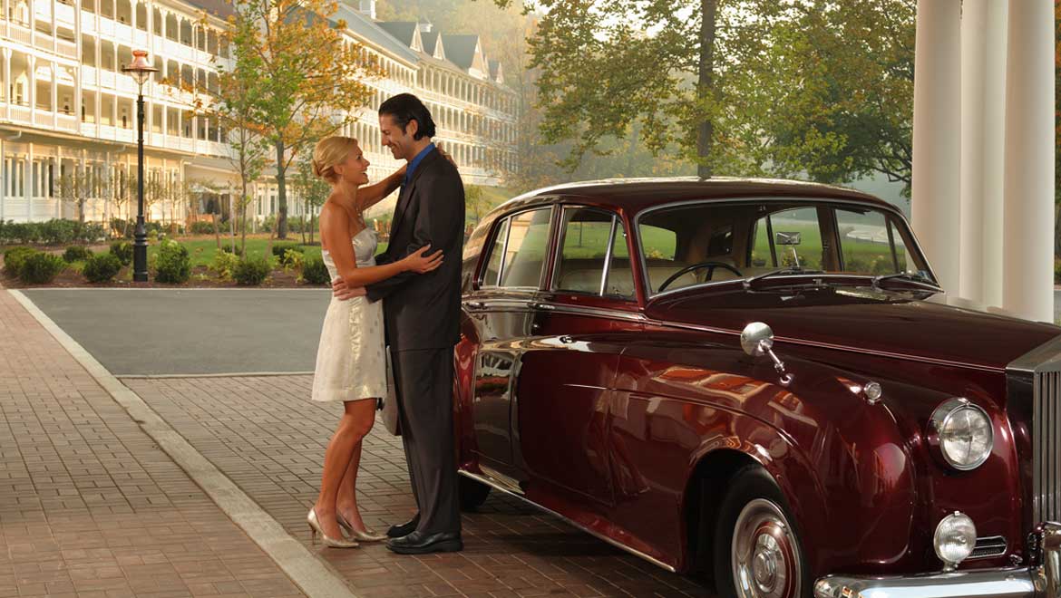 Couple posing by vintage car