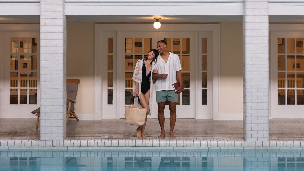 Couple at edge of indoor pool.
