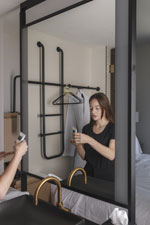 A woman stands in front of double-sided a mirror